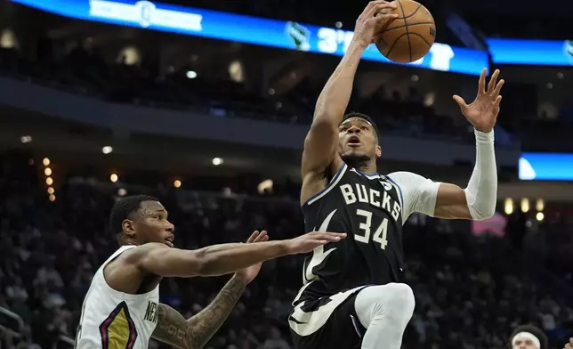 Milwaukee Bucks' Giannis Antetokounmpo (34) drives to the basket against New Orleans Pelicans' Jamal Cain, left, during the first half of an NBA basketball game Thursday, April 10, 2025, in Milwaukee. (AP Photo/Aaron Gash)