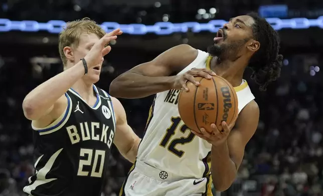 New Orleans Pelicans' Antonio Reeves (12) drives to the basket against Milwaukee Bucks' AJ Green during the second half of an NBA basketball game Thursday, April 10, 2025, in Milwaukee. (AP Photo/Aaron Gash)