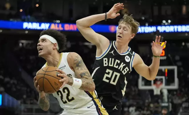 New Orleans Pelicans' Lester Quinones (22) drives to the basket against Milwaukee Bucks' AJ Green during the second half of an NBA basketball game Thursday, April 10, 2025, in Milwaukee. (AP Photo/Aaron Gash)