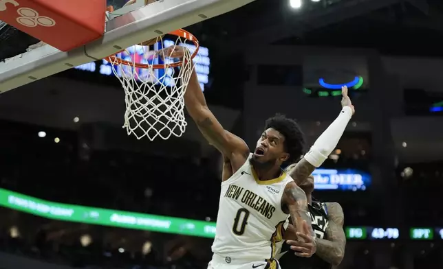 New Orleans Pelicans' Keion Brooks Jr. (0) misses a dunk against Milwaukee Bucks' Kevin Porter Jr., right, during the second half of an NBA basketball game Thursday, April 10, 2025, in Milwaukee. (AP Photo/Aaron Gash)