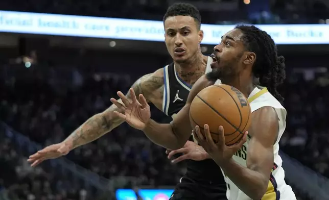 New Orleans Pelicans' Antonio Reeves drives to the basket against Milwaukee Bucks' Kyle Kuzma during the second half of an NBA basketball game Thursday, April 10, 2025, in Milwaukee. (AP Photo/Aaron Gash)