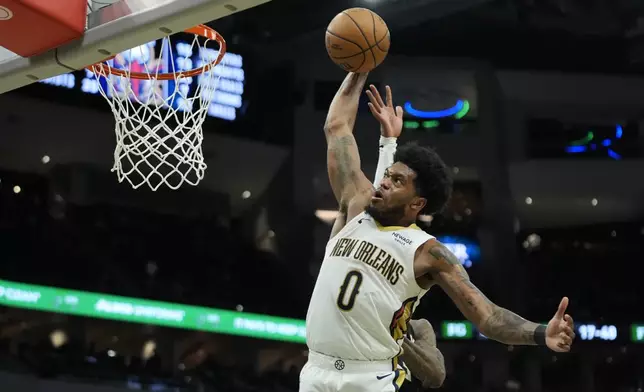 New Orleans Pelicans' Keion Brooks Jr. (0) misses a dunk against Milwaukee Bucks' Kevin Porter Jr., behind, during the second half of an NBA basketball game Thursday, April 10, 2025, in Milwaukee. (AP Photo/Aaron Gash)