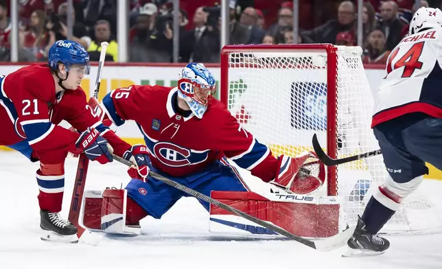 Montreal Canadiens goaltender Jakub Dobes (75) makes a save against Washington Capitals' Connor McMichael (24) during the second period of Game 4 in an NHL hockey first-round playoff series in Montreal, Sunday, April 27, 2025. (Christopher Katsarov/The Canadian Press via AP)