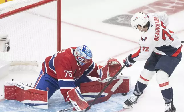 Montreal Canadiens goaltender Jakub Dobes (75) stops a shot by Washington Capitals' Anthony Beauvillier (72) during the second period of Game 4 in an NHL hockey first-round playoff series in Montreal, Sunday, April 27, 2025. (Christinne Muschi/The Canadian Press via AP)
