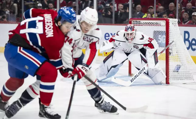 Washington Capitals goaltender Logan Thompson, right, watches Montreal Canadiens' Josh Anderson (17) and Capitals' John Carlson (74) vie for the puck during the first period of Game 4 in an NHL hockey first-round playoff series in Montreal, Sunday, April 27, 2025. (Christopher Katsarov/The Canadian Press via AP)