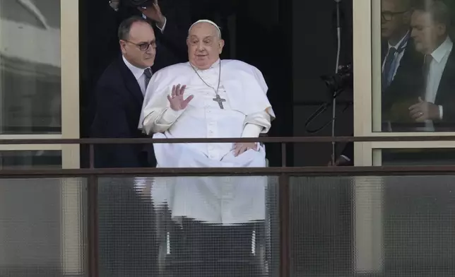 FILE - Pope Francis waves as he appears at a window of the Agostino Gemelli Polyclinic in Rome, Sunday, March 23, 2025, where he has been treated for bronchitis and bilateral pneumonia since Feb. 14. (AP Photo/Andrew Medichini, File)