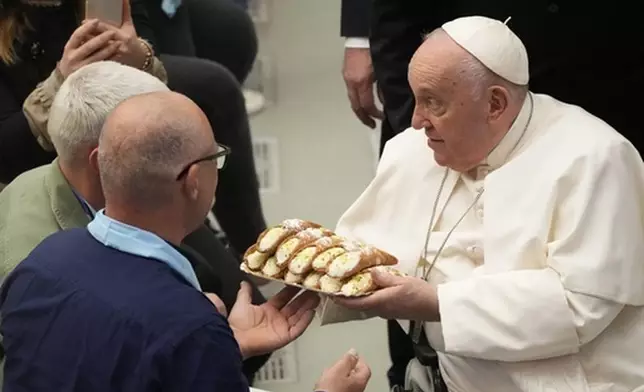 FILE - Pope Francis receives Cannoli Siciliani (traditional Sicilian pastries) as he meets with faithful of Pilgrimage of the Vocationist Family, at the Vatican, Monday, May 22, 2023. (AP Photo/Gregorio Borgia, File)