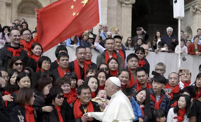 FILE - In this April 18, 2018 file photo, Pope Francis meets a group of faithful from China at the end of his weekly general audience in St. Peter's Square, at the Vatican. The Vatican on Tuesday, Sept. 29, 2020, answered its critics and justified its decision to pursue an extension of an agreement with China over bishop nominations, acknowledging difficulties but insisting that limited, positive results had been achieved.(AP Photo/Gregorio Borgia, file)