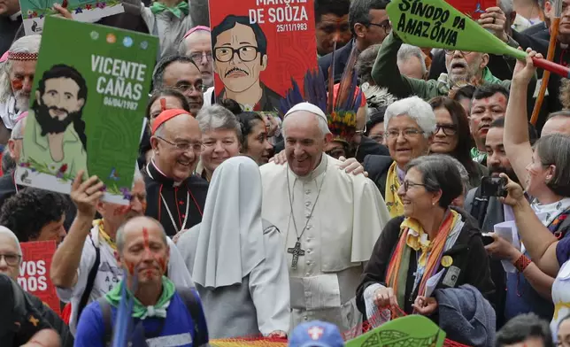 FILE - Pope Francis smiles to a nun as he walks in procession on the occasion of the Amazon synod, at the Vatican, Monday, Oct. 7, 2019. (AP Photo/Andrew Medichini, file)