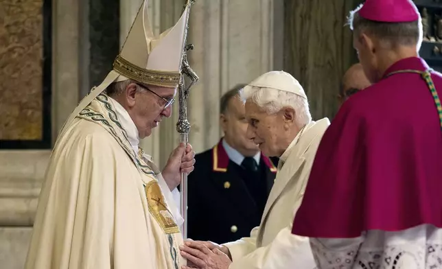 FILE - Pope Francis, left, stands in front of Emeritus Pope Benedict XVI entering St. Peter's Basilica accompanied by Monsignor Georg Gaenswein, right with back to camera, at the Vatican, Tuesday, Dec. 8, 2015. (AP Photo/Andrew Medichini, file)
