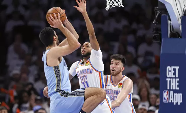 Memphis Grizzlies forward Santi Aldama, left, looks to shoot as Oklahoma City Thunder guard Isaiah Joe (11) and forward Chet Holmgren, right, defend during the first half in Game 1 of an NBA first-round playoff series, Sunday, April 20, 2025, in Oklahoma City. (AP Photo/Nate Billings)