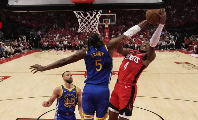 Golden State Warriors forward Kevon Looney (5) blocks a shot by Houston Rockets guard Jalen Green (4) during the first half of Game 1 of an NBA basketball first-round playoff series in Houston, Sunday, April 20, 2025. (AP Photo/Ashley Landis)