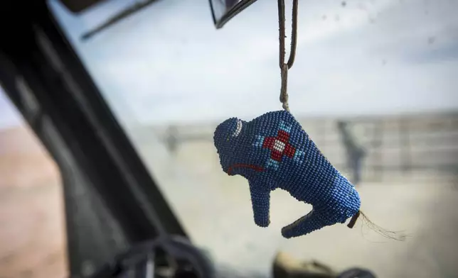 Beadwork, with the likeness of a buffalo, dangles from a rearview mirror in a vehicle used by the Wind River Tribal Buffalo Initiative during the buffalo release at the Eastern Shoshone Buffalo Enclosure on Friday, April 11, 2025, on the Wind River Reservation near Morton, Wyo. (AP Photo/Amber Baesler)