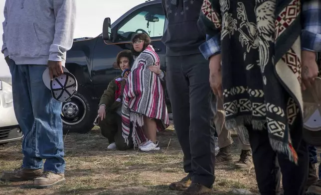Oakley Boycott, left, embraces Ori Downer, 8, during the buffalo release at the Eastern Shoshone Buffalo Enclosure on Friday, April 11, 2025, on the Wind River Reservation near Morton, Wyo. (AP Photo/Amber Baesler)