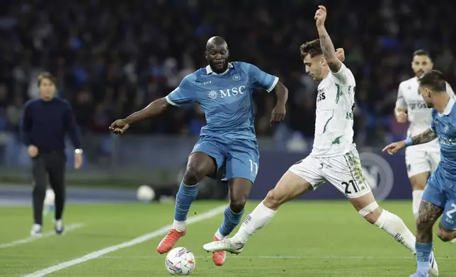 Napoli's Romelu Lukaku, left, and Empoli's Mattia Viti challenge for the ball during the Serie A soccer match between Napoli and Empoli at the Diego Armando Maradona Stadium in Naples, Italy, Monday, April 14 , 2025. (Alessandro Garofalo/LaPresse via AP)
