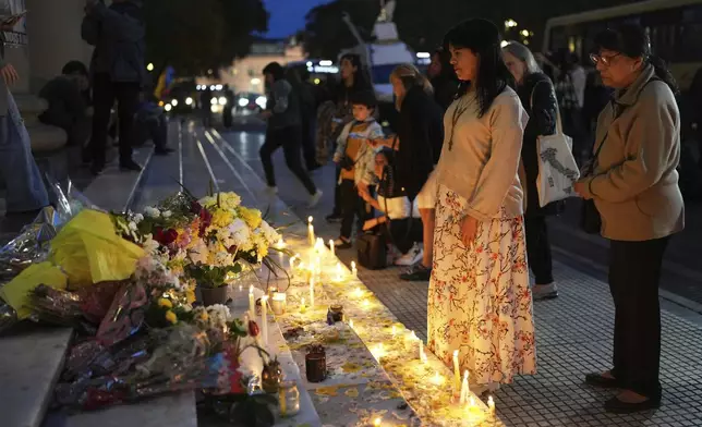 People stand in front of candles for the late Pope Francis on the grand staircase of the Cathedral in Buenos Aires, Argentina, Tuesday, April 22, 2025. (AP Photo/Rodrigo Abd)