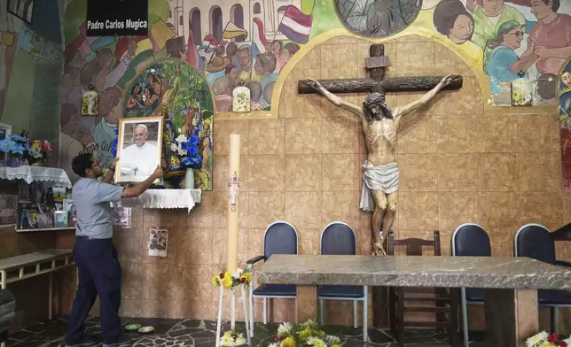 Father Jesus Carides holds a portrait at the Caacupe Parish, which Pope Francis often visited and preached at, in Buenos Aires, Argentina, Monday, April 21, 2025. (AP Photo/Natacha Pisarenko)