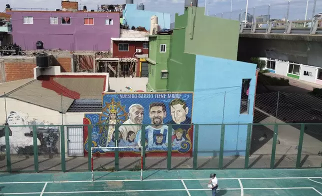 A mural depicts the late Pope Francis alongside soccer player Lionel Messi in the Carlos Mugica neighborhood in Buenos Aires, Argentina, Monday, April 21, 2025. (AP Photo/Rodrigo Abd)