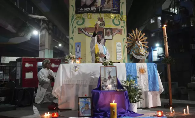 A priest holds Mass to honor the late Pope Francis under a highway bridge in the Carlos Mugica neighborhood of Buenos Aires, Argentina, Monday, April 21, 2025. (AP Photo/Rodrigo Abd)