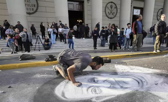 A street artist chalks a portrait of the late Pope Francis in front of the Cathedral in Buenos Aires, Argentina, Monday, April 21, 2025. (AP Photo/Gustavo Garello)