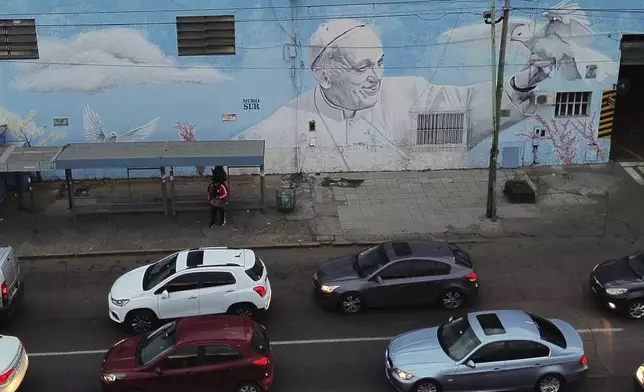 Vehicles drive past a mural of the late Pope Francis in Buenos Aires, Argentina Monday, April 21, 2025. (AP Photo/Mario De Fina)