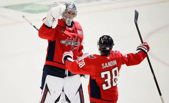 Washington Capitals goaltender Logan Thompson, left, celebrates with defenseman Rasmus Sandin (38) after Game 2 of a first-round NHL hockey playoff series against the Montreal Canadiens Wednesday, April 23, 2025, in Washington. (AP Photo/Nick Wass)