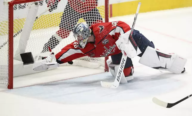 Washington Capitals goaltender Logan Thompson dives for the puck in the third period of Game 2 of a first-round NHL hockey playoff series against the Montreal Canadiens Wednesday, April 23, 2025, in Washington. (AP Photo/Nick Wass)