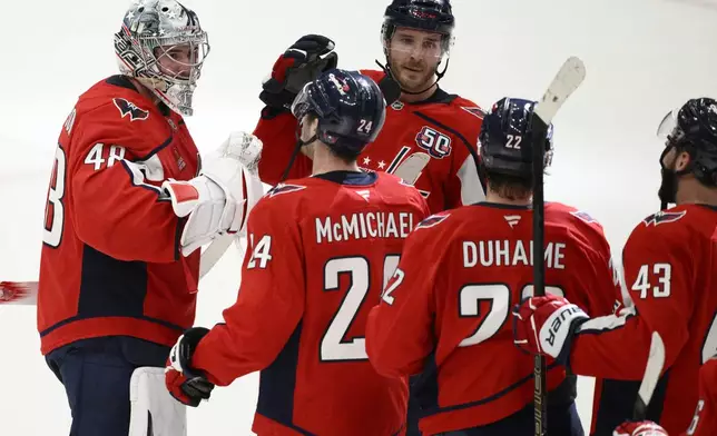 Washington Capitals goaltender Logan Thompson (48) celebrates with center Connor McMichael (24) and others after Game 2 of a first-round NHL hockey playoff series against the Montreal Canadiens Wednesday, April 23, 2025, in Washington. (AP Photo/Nick Wass)