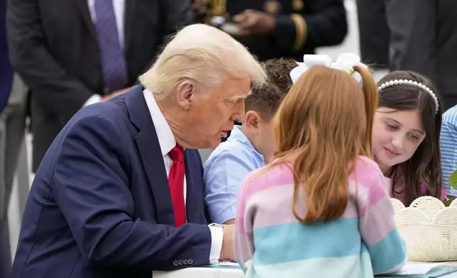 President Donald Trump sits with children as he participates in the White House Easter Egg Roll on the South Lawn of the White House, Monday, April 21, 2025, in Washington. (AP Photo/Mark Schiefelbein)