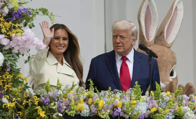 President Donald Trump watches as first lady Melania Trump waves from the Blue Room Balcony during the White House Easter Egg Roll on the South Lawn of the White House, Monday, April 21, 2025, in Washington. (AP Photo/Alex Brandon)
