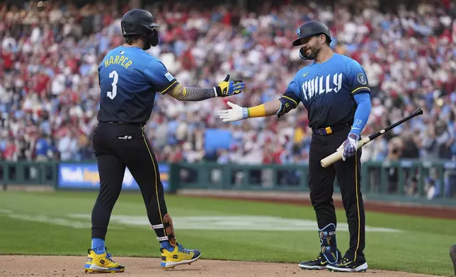 Philadelphia Phillies' Bryce Harper (3) celebrates after his two-run home run off Miami Marlins pitcher Sandy Alcantara with teammate Kyle Schwarber, right, during the first inning of a baseball game, Friday, April 18, 2025, in Philadelphia. (AP Photo/Matt Rourke)