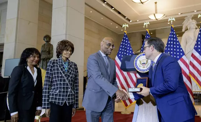 House Speaker Mike Johnson, R-La., right, presents the Congressional Gold Medal to Stanley Earley III, son of Lt. Col. Charity Adams Earley, second from right, as Judith Earley, second from left, and retired Amy Col. Edna W. Cummings, left, watch during a ceremony honoring the Six Triple Eight, on Capitol Hill, Tuesday, April 29, 2025, in Washington. (AP Photo/Rod Lamkey, Jr.)