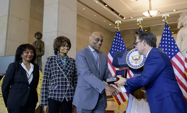 House Speaker Mike Johnson, R-La., right, presents the Congressional Gold Medal to Stanley Earley III, son of Lt. Col. Charity Adams Earley, second from right, as Judith Earley, second from left, and retired Amy Col. Edna W. Cummings, left, watch during a ceremony honoring the Six Triple Eight, on Capitol Hill, Tuesday, April 29, 2025, in Washington. (AP Photo/Rod Lamkey, Jr.)
