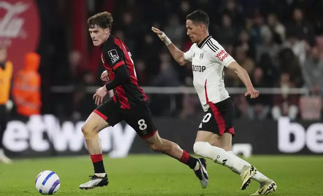 Bournemouth's Alex Scott, left, and Fulham's Sasa Lukic battle for the ball during the English Premier League soccer match between Bournemouth and Fulham at the Vitality Stadium, Bournemouth, England, Monday, April 14, 2025. (John Walton/PA via AP)