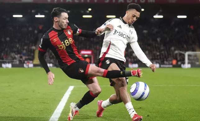 Bournemouth's Adam Smith, left, and Fulham's Antonee Robinson battle for the ball during the English Premier League soccer match between Bournemouth and Fulham at the Vitality Stadium, Bournemouth, England, Monday, April 14, 2025. (John Walton/PA via AP)