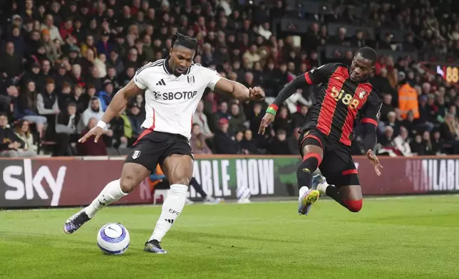 Fulham's Adama Traore, left, and Bournemouth's Dango Ouattara battle for the ball during the English Premier League soccer match between Bournemouth and Fulham at the Vitality Stadium, Bournemouth, England, Monday, April 14, 2025. (John Walton/PA via AP)
