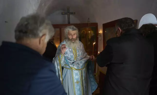 Orthodox Christian monk Father Spyridon of Amorgos conducts the Divine Liturgy in the chapel of Panagia Evangelistria, in Amorgos island, Greece, on Tuesday, March 25, 2025. (AP Photo/Petros Giannakouris)