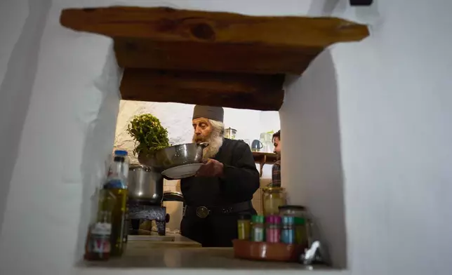 Orthodox Christian monk Father Spyridon of Amorgos, cooks in the kitchen of the Monastery of Panagia Hozoviotissa, in Amorgos island, on Monday, March 24, 2025. (AP Photo/Petros Giannakouris)