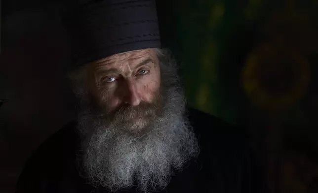 Orthodox Christian monk Father Spyridon looks on inside the chapel of the Monastery of Panagia Hozoviotissa in Amorgos island, Greece, on Thursday, March 27, 2025. (AP Photo/Petros Giannakouris)