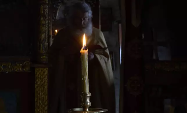 Orthodox Christian monk Father Spyridon conducts the Divine Liturgy in the chapel of the Monastery of Panagia Hozoviotissa in Amorgos island, Greece, on Sunday, March 30, 2025. (AP Photo/Petros Giannakouris)