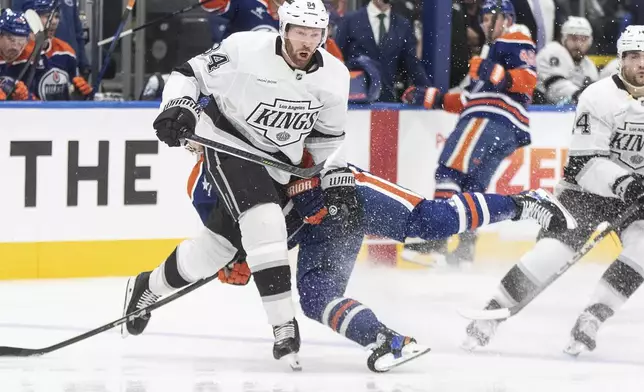 Los Angeles Kings' Vladislav Gavrikov (84) checks Edmonton Oilers' Kasperi Kapanen (42) during the second period of an NHL hockey game in Edmonton, Alberta, Monday, April 14, 2025. (Jason Franson/The Canadian Press via AP)