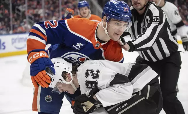 Los Angeles Kings' Brandt Clarke, bottom, and Edmonton Oilers' Vasily Podkolzin, left, fight during the second period of an NHL hockey game in Edmonton, Alberta, Monday, April 14, 2025. (Jason Franson/The Canadian Press via AP)