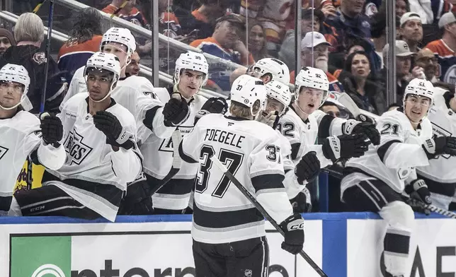 Los Angeles Kings' Warren Foegele (37) celebrates with teammates after a goal against the Edmonton Oilers during first-period NHL hockey game action in Edmonton, Alberta, Monday, April 14, 2025. (Jason Franson/The Canadian Press via AP)