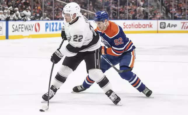Los Angeles Kings' Kevin Fiala (22) is pursued by Edmonton Oilers' Vasily Podkolzin (92) during first-period NHL hockey game action in Edmonton, Alberta, Monday, April 14, 2025. (Jason Franson/The Canadian Press via AP)