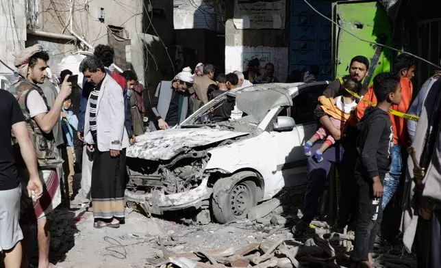 Yemenis watch a damaged vehicle at Farwah popular market, which Houthis said was struck by U.S. airstrikes, in Sanaa, Yemen, Monday, April 21, 2025. (AP Photo)