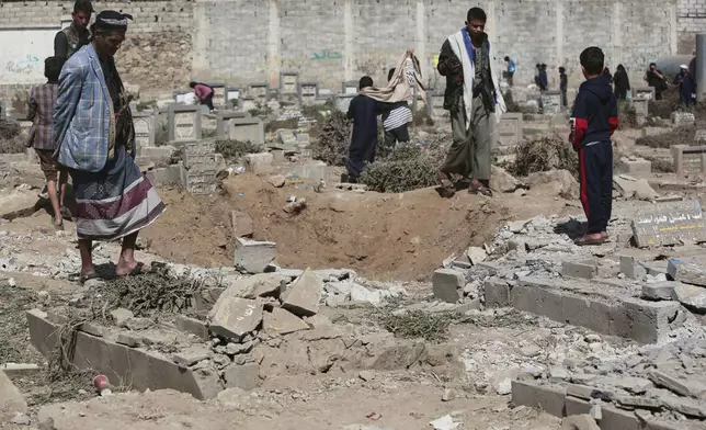 Yemenis watch a hole at Magel Al-Dammah cemetery a day after it was struck by U.S. airstrikes in Sanaa, Yemen, Sunday, April 20, 2025. (AP Photo)