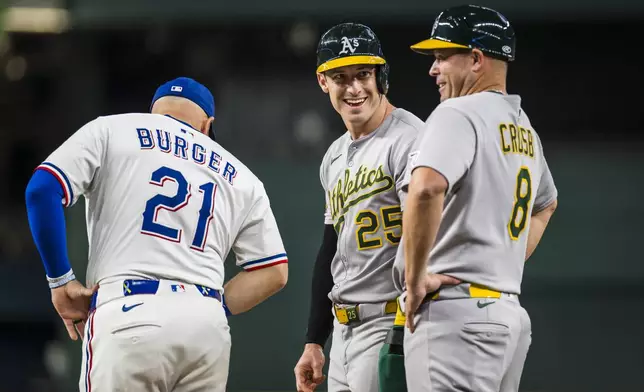 Athletics' Brent Rooker (25) talks with first base coach Bobby Crosbyduring the fourth inning of a baseball game against the Texas Rangers, Monday, April 28, 2025, in Arlington, Texas. (AP Photo/Jessica Tobias)