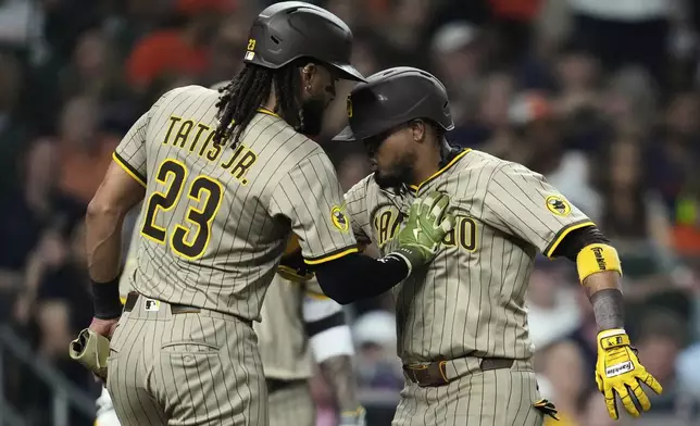 San Diego Padres' Luis Arraez, right, celebrates with Fernando Tatis Jr. (23) after hitting a home run during the seventh inning of a baseball game against the Houston Astros in Houston, Friday, April 18, 2025. (AP Photo/Ashley Landis)