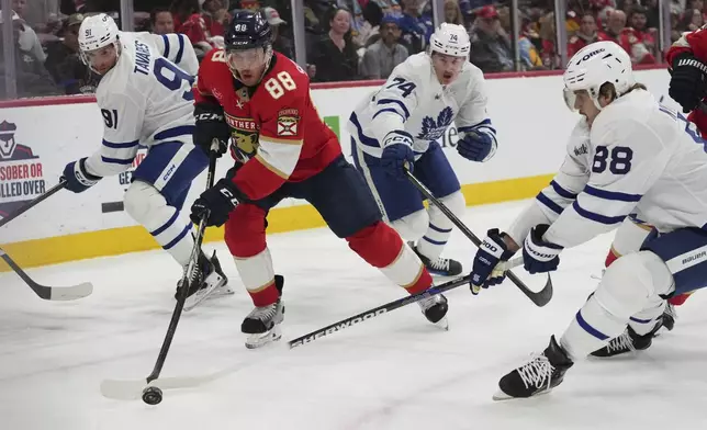 Florida Panthers defenseman Nate Schmidt (88), second from left, skates with the puck as Toronto Maple Leafs right wing William Nylander (88), right, defends during the first period of an NHL hockey game, Tuesday, April 8, 2025, in Sunrise, Fla. (AP Photo/Lynne Sladky)