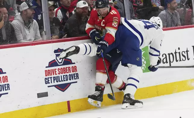 Florida Panthers center Aleksander Barkov, left, and Toronto Maple Leafs center Auston Matthews, right, go up against the boards during the second period of an NHL hockey game, Tuesday, April 8, 2025, in Sunrise, Fla. (AP Photo/Lynne Sladky)